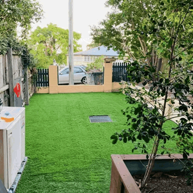 a backyard with a fence and a few cars parked in it
