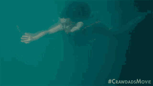 a woman is swimming in the ocean with the hashtag #crawldadsmovie