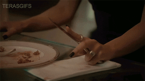 a woman in a suit and tie is sitting at a table with candles and the word terasces on the bottom right