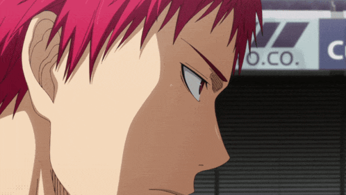 a man with red hair stands in front of a sign that says o.co