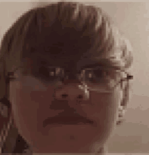 a close up of a person 's face wearing glasses and making a funny face .
