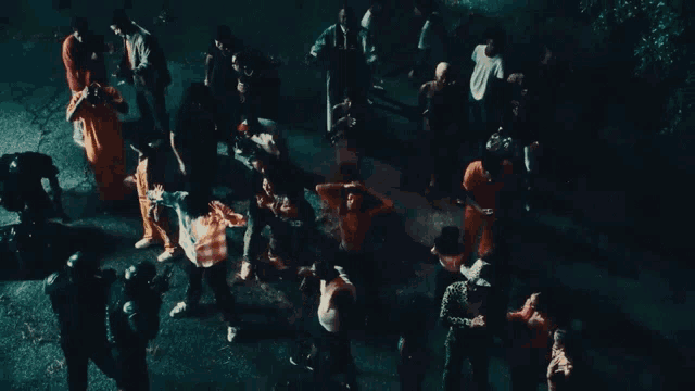 a large group of people are gathered on a street at night
