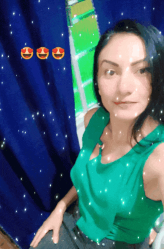 a woman in a green shirt is sitting in front of a blue curtain