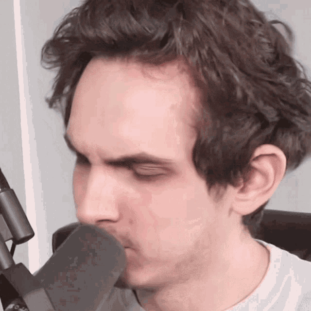 a close up of a man 's face with a microphone in front of him