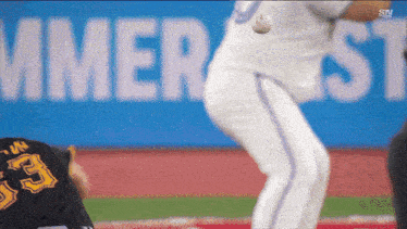 a baseball player throws a ball in front of a banner that says summer st.