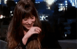 a woman with a ring on her finger is laughing and covering her mouth with her hand