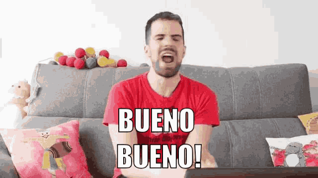 a man in a red shirt is sitting on a couch with his mouth open and says bueno bueno .
