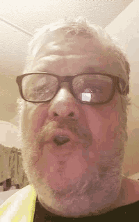 a man with glasses and a beard is making a face