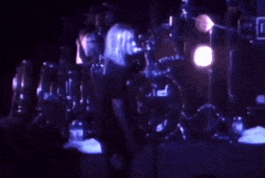 a person playing drums with a pearl drum set in the background