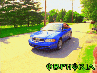 a blue car is driving down a street with the word obphoria on the bottom right