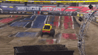 a monster truck is driving through a dirt track at a monster jam event