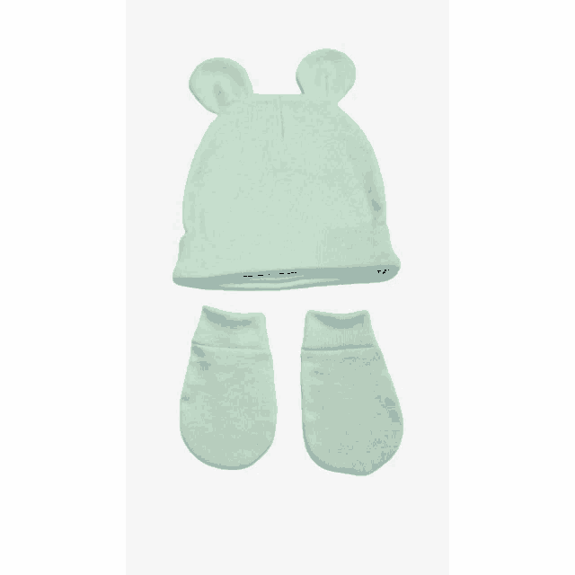 a baby 's hat and mittens are on a white surface