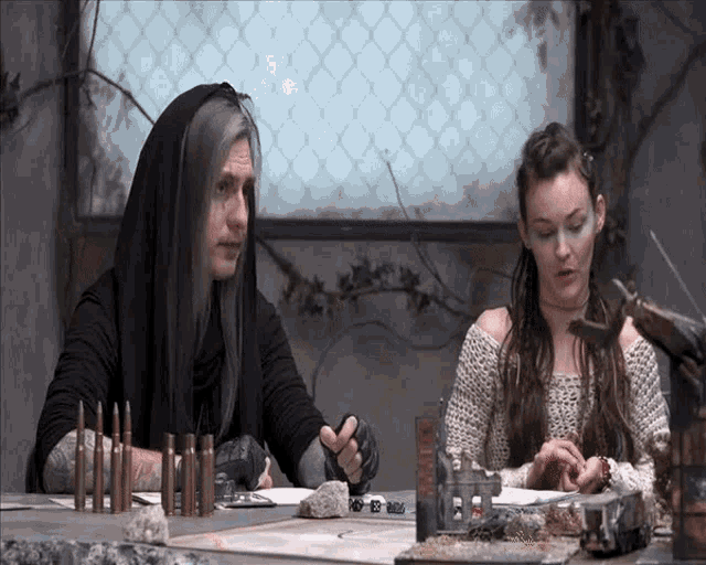 a man and a woman are sitting at a table with bullets on it and a sign that says ' army '