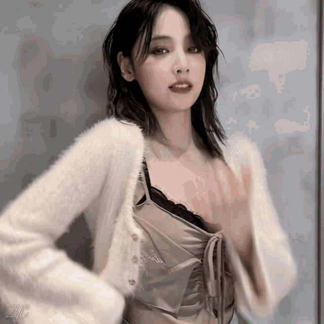 a woman wearing a white cardigan and a brown top with the word powder written on it