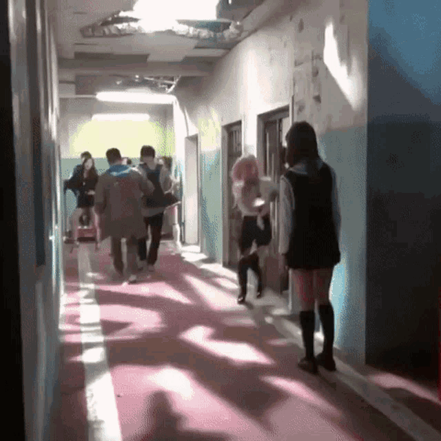 a girl in a school uniform is walking down a hallway