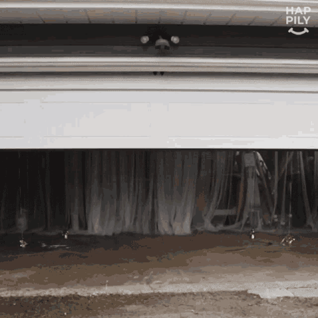 a white garage door with the word hap pily on the bottom right