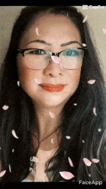 a woman wearing glasses is surrounded by falling petals