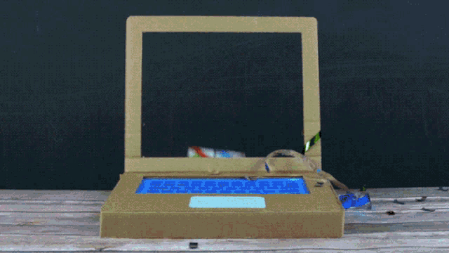 a person is holding a gift box in front of a laptop