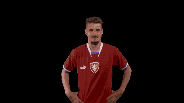 a man wearing a red puma shirt with a lion on the front