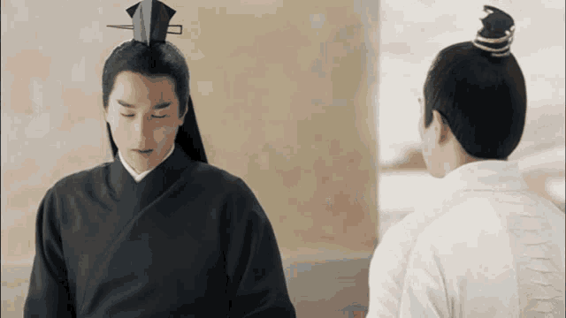 two men are standing next to each other and one is wearing a black kimono