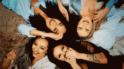a group of women are laying in a circle on the floor laughing