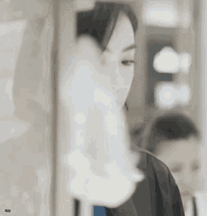 a blurry picture of a woman with a reflection of a man in the glass