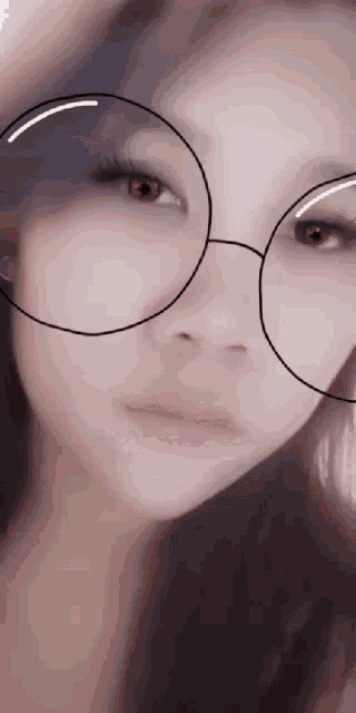 a close up of a woman 's face with glasses on
