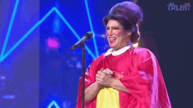 a woman singing into a microphone in front of a sign that says talent