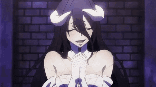 a woman with horns is praying with her eyes closed .
