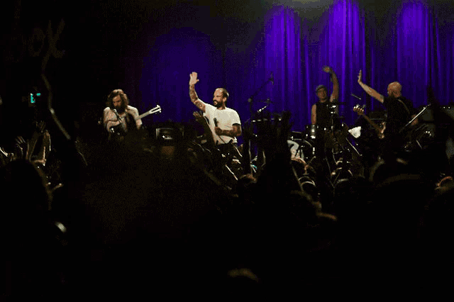 a group of people on a stage with an exit sign in the back