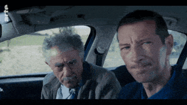 two men are sitting in a car with the letters rtl on the screen