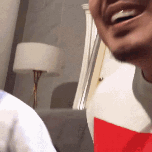 a man in a red and white shirt is smiling