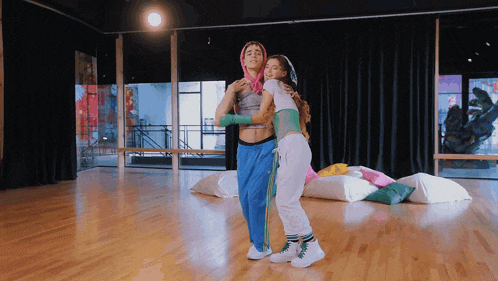 two women are hugging each other in a dance room