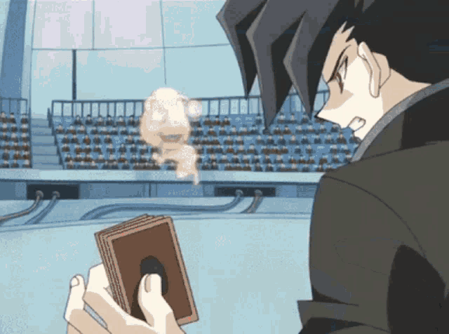 a man in a black suit is holding a stack of cards in front of a crowd
