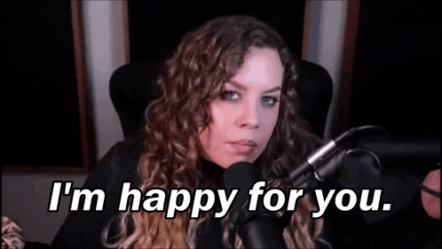 a woman is sitting in front of a microphone and saying i 'm happy for you .