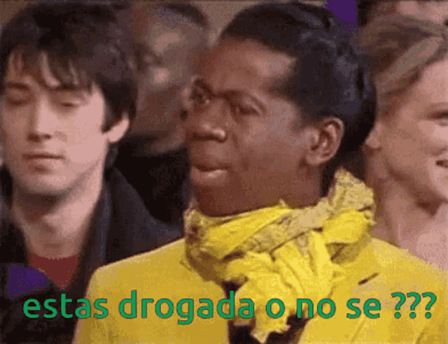 a man in a yellow jacket and scarf says " estas drogada o no se "