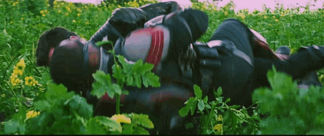a man in a superhero suit is laying in a field of flowers
