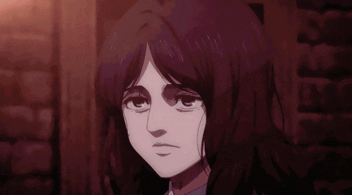 a close up of a woman 's face with a brick wall behind her