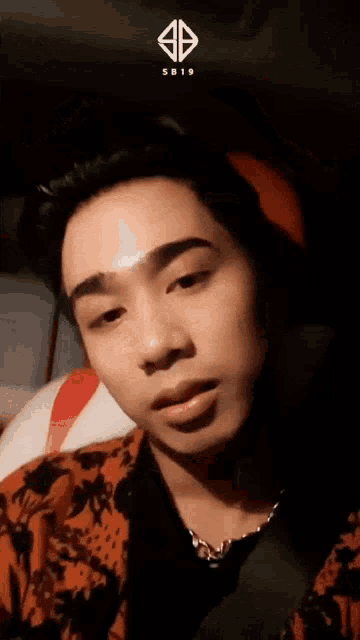 a close up of a man 's face with a sb19 logo on the bottom right