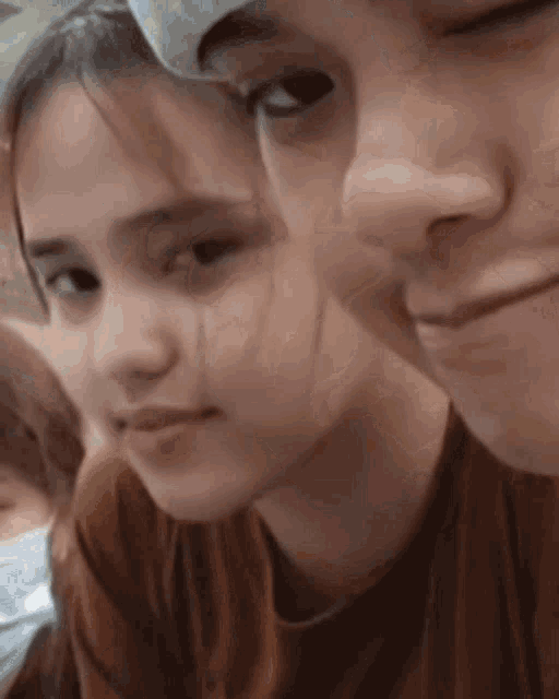 a close up of a man and a woman 's faces with their eyes closed .