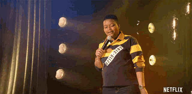 a netflix ad shows a person holding a microphone on stage