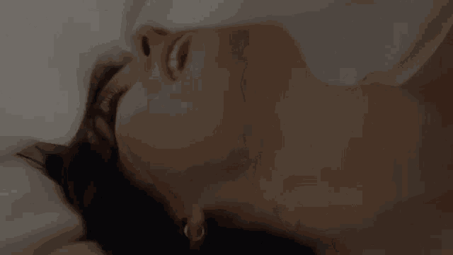 a woman is laying on a bed with her mouth open .
