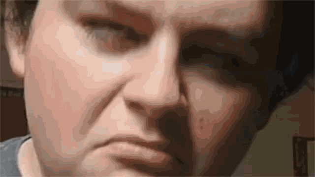 a close up of a person 's face with a serious look on their face .