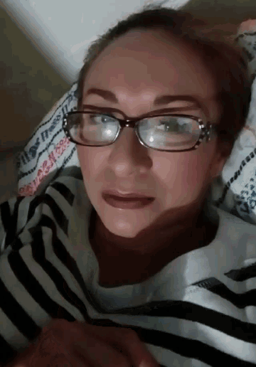 a woman wearing glasses and a striped shirt is laying down