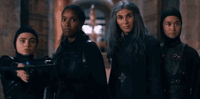 a group of young women are standing next to each other in a hallway .