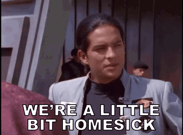 a man in a suit is talking to another man and says we 're a little bit homesick