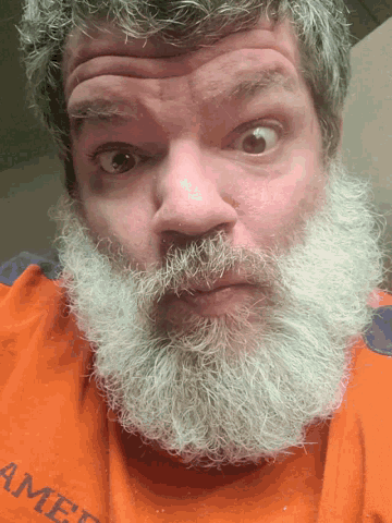 a man with a beard is wearing an orange shirt that says amer on it