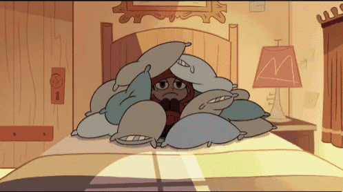a cartoon character is hiding under a pile of pillows and a lamp with the letter m on it