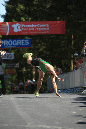 a man is doing a handstand in front of a progress banner