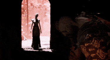 a man in armor is holding a sword with fire coming out of it